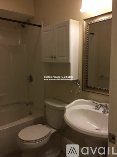 A white toilet in a bathroom with a sink and a mirror.