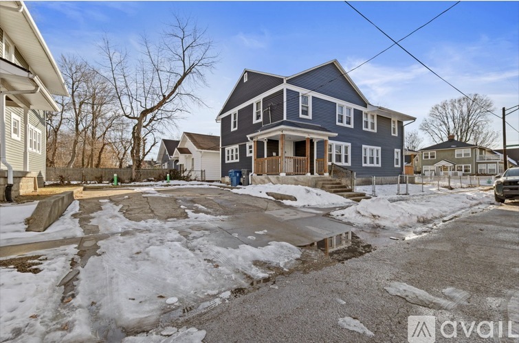 A house with a blue and white exterior is surrounded by snow.