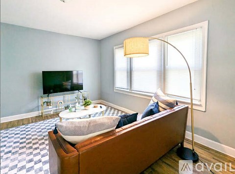A living room with a brown couch and a television.