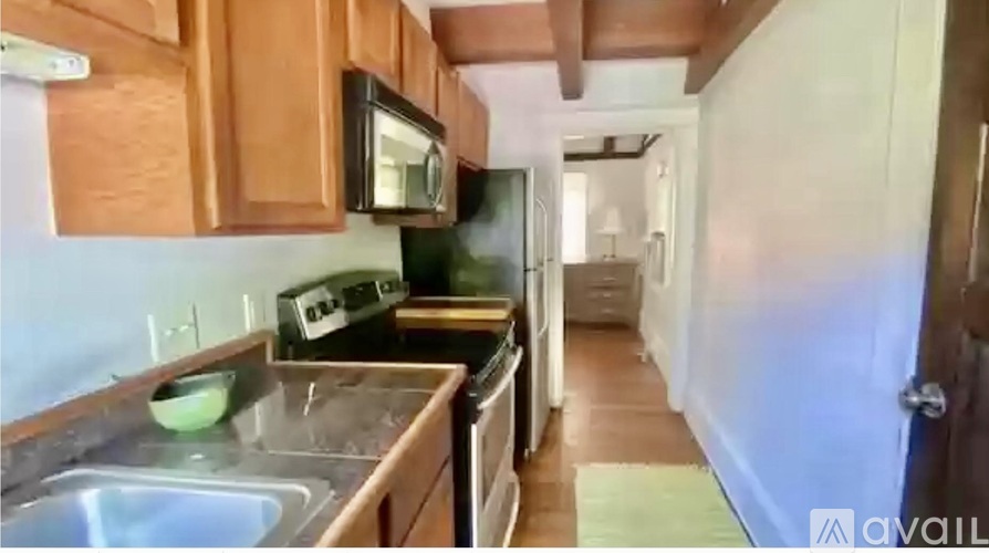 A kitchen with wooden cabinets and a stainless steel sink.