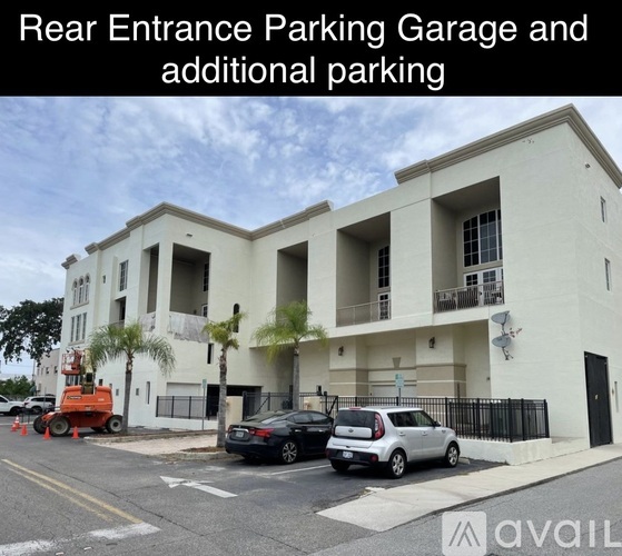 A building with a rear entrance parking garage and additional parking.