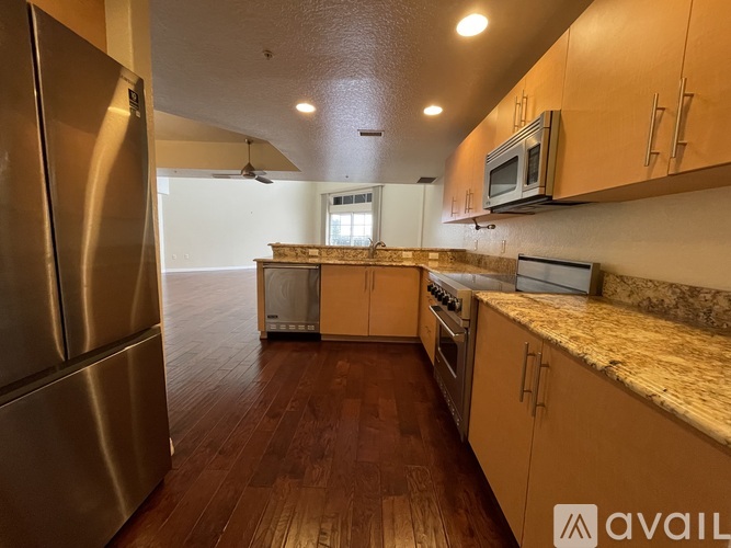 A kitchen with wooden floors and stainless steel appliances.