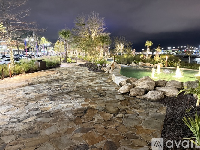 A stone pathway leads to a lit-up area.