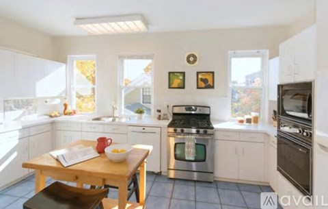 A kitchen with a wooden table and stainless steel appliances.
