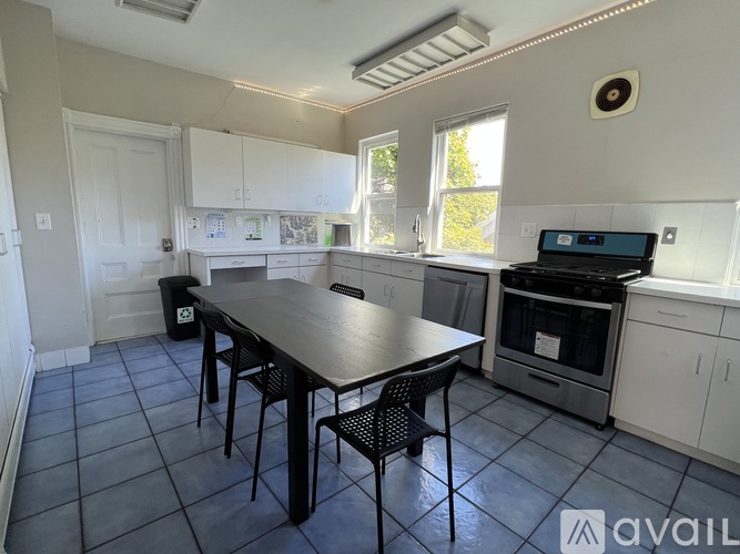 A kitchen with a table and chairs in front of a stove.