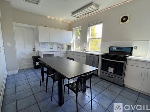 A kitchen with a table and chairs in front of a stove.