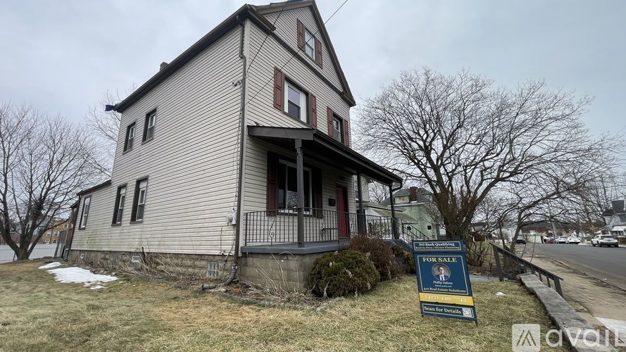 A house with a for sale sign in front of it.