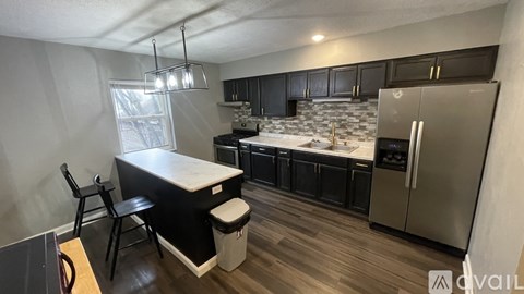 A kitchen with a black and white color scheme and stainless steel appliances.