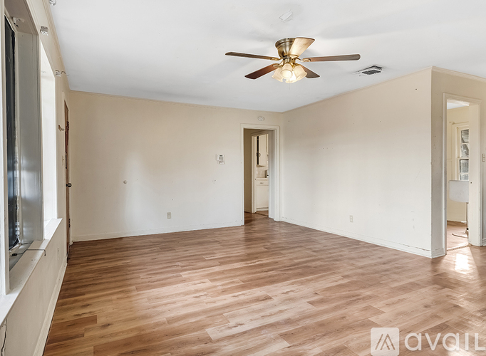 A room with wooden floors and a ceiling fan.