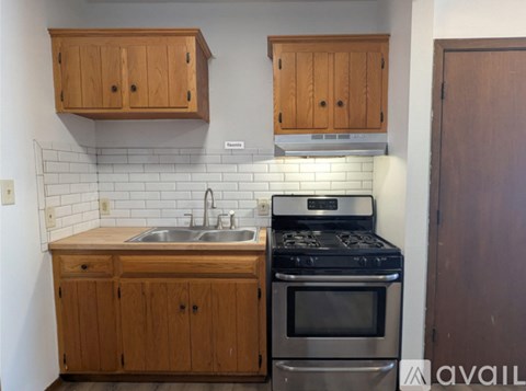 A kitchen with wooden cabinets and a stove top oven.
