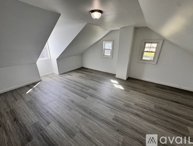 A room with wooden flooring and a window.