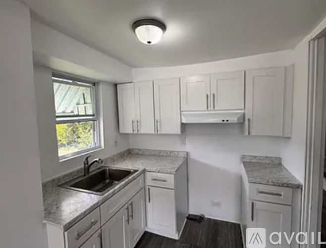 A kitchen with white cabinets and granite countertops.