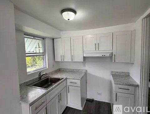 A kitchen with white cabinets and granite countertops.