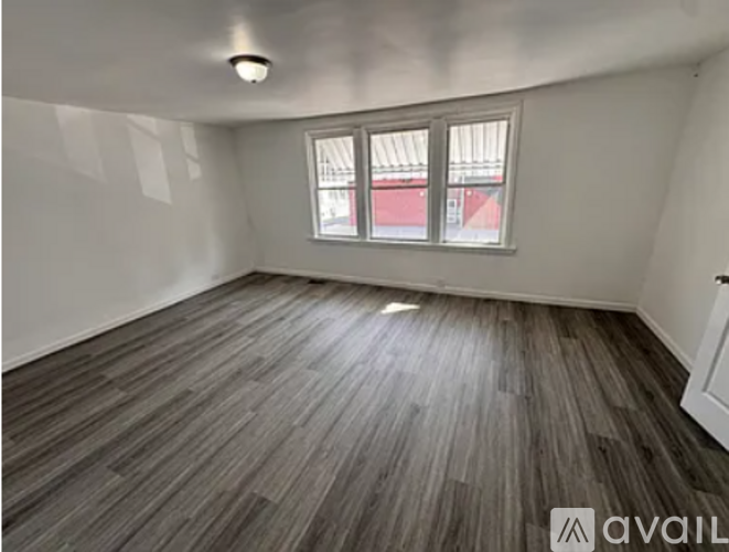 A room with wooden flooring and a window.