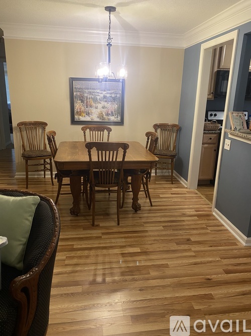 A dining room with a wooden table and chairs.