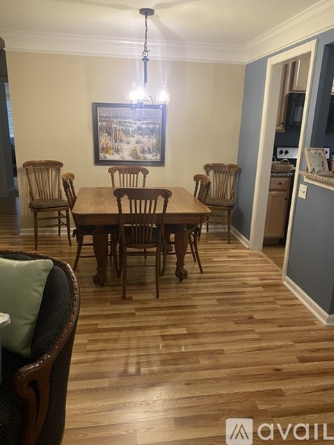 A dining room with a wooden table and chairs.