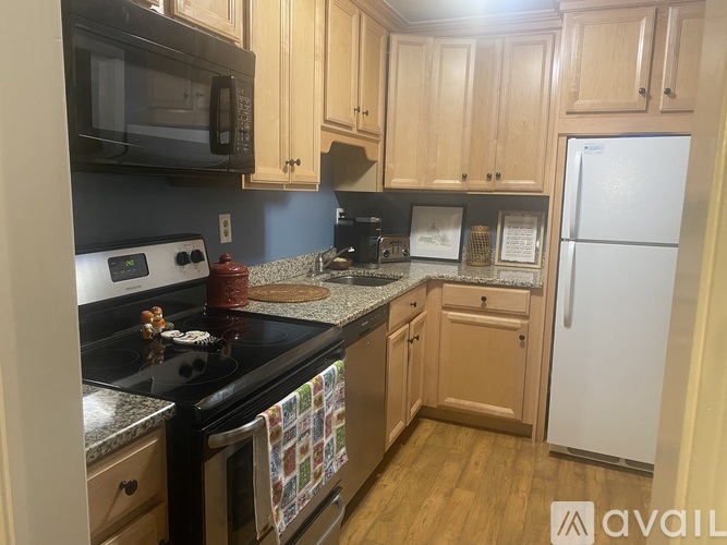 A kitchen with wooden cabinets and a black stove top.