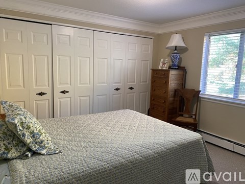 A bedroom with a bed, dresser, and wardrobe.