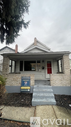 A house with a for sale sign in front.