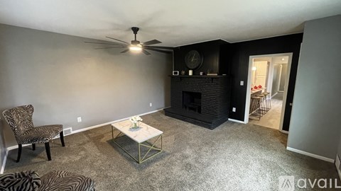 A living room with a zebra print chair and a fireplace.