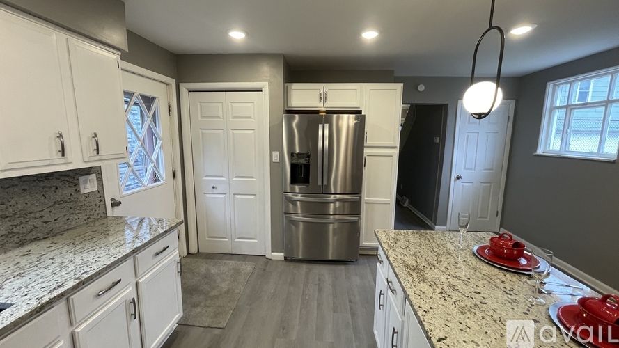 A kitchen with white cabinets and a granite countertop.