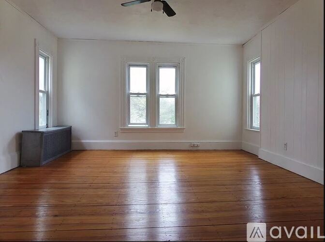 A room with wooden floors and a ceiling fan.