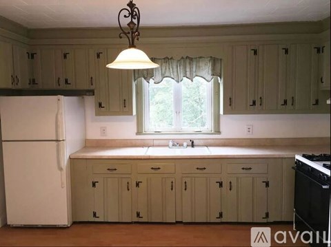 A kitchen with white cabinets and a white refrigerator.
