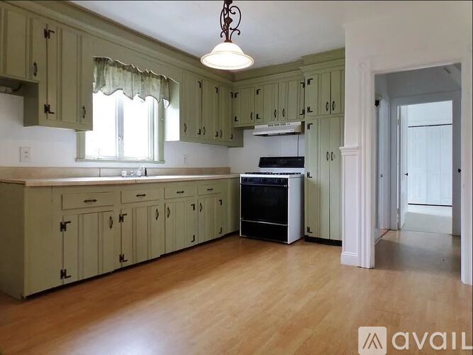 A kitchen with green cabinets and a white counter top.