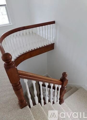 A wooden staircase with a white railing.