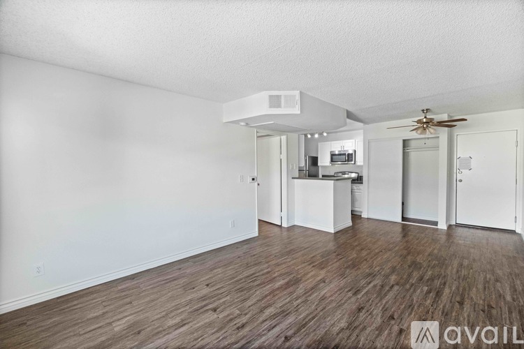 A kitchen with white cabinets and a black countertop is available for rent.