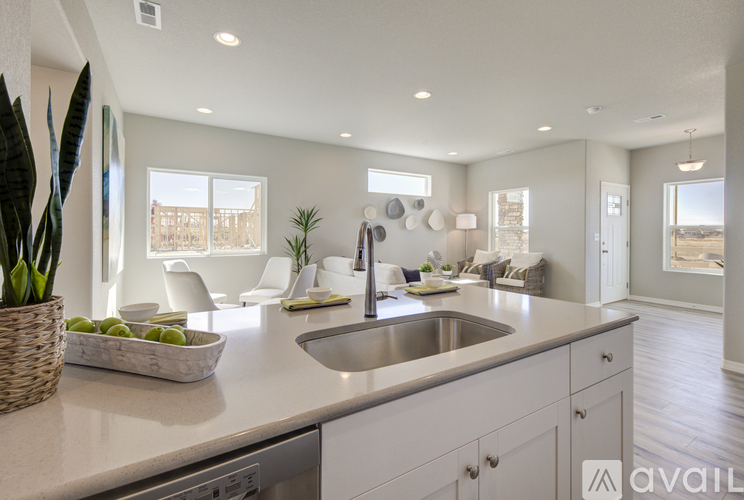 A modern kitchen with a large island and a view of the backyard.