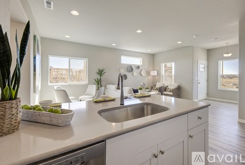 A modern kitchen with a large island and a view of the backyard.