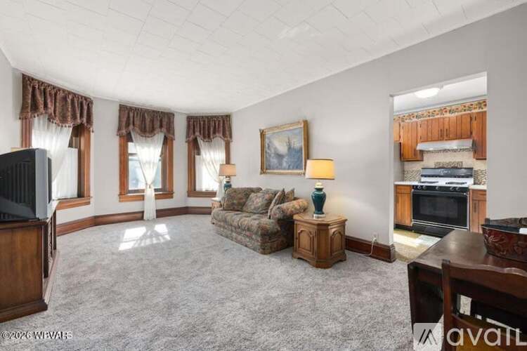 A living room with a couch, a television, and a fireplace.