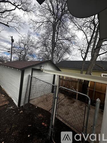 A backyard with a fence and a satellite dish.