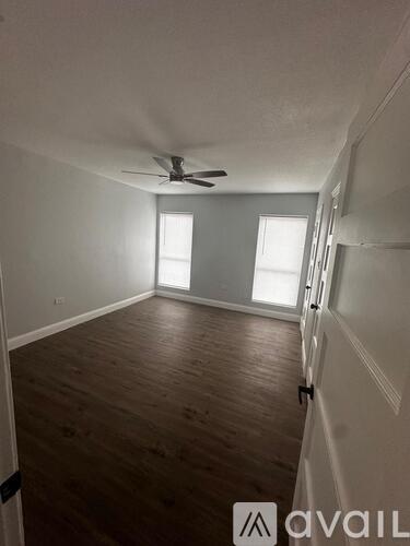 A room with wooden floors and a ceiling fan.