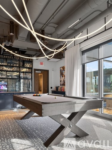 A pool table in a room with a view of the city.