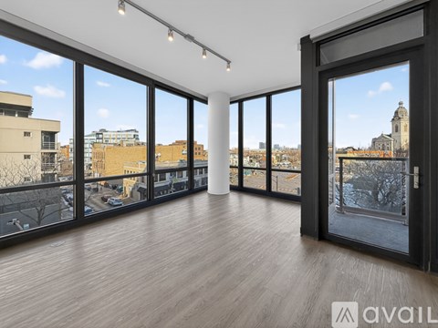 A spacious room with large windows overlooking a cityscape.