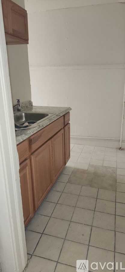 A kitchen with a sink and brown cabinets.