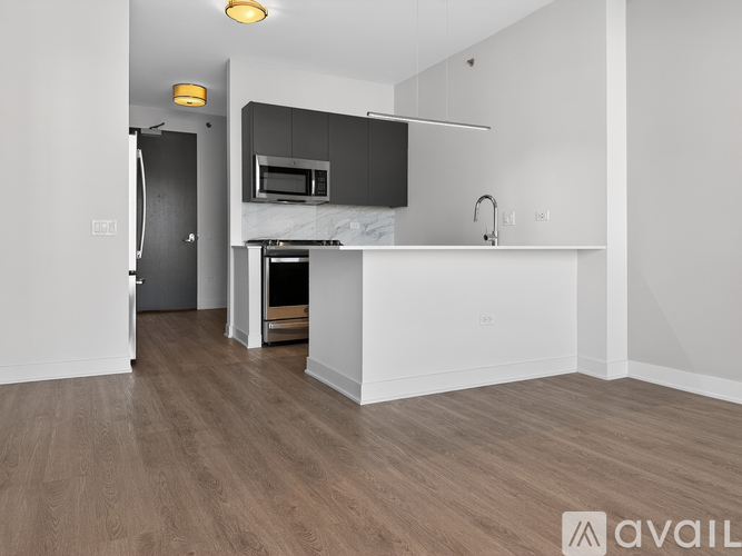A kitchen with a white countertop and a microwave above it.