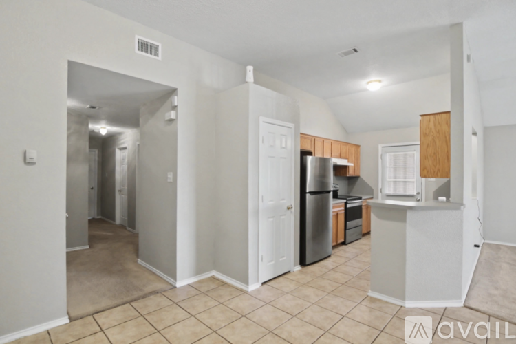 A kitchen area with a refrigerator, sink, and cabinets.