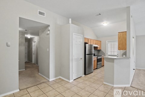 A kitchen area with a refrigerator, sink, and cabinets.