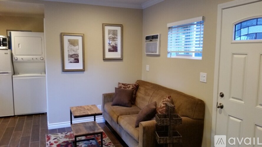 A living room with a couch, a coffee table, and pictures on the wall.