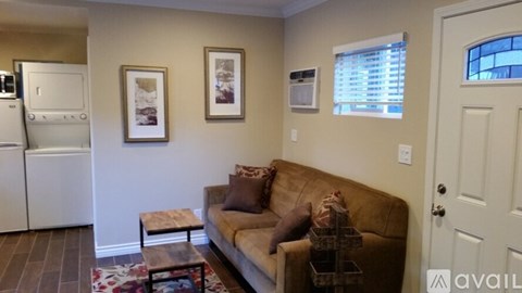 A living room with a couch, a coffee table, and pictures on the wall.