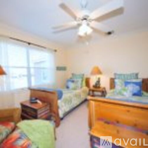 A bedroom with two beds and a dresser.