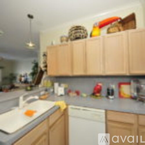 A kitchen with wooden cabinets and a white dishwasher.