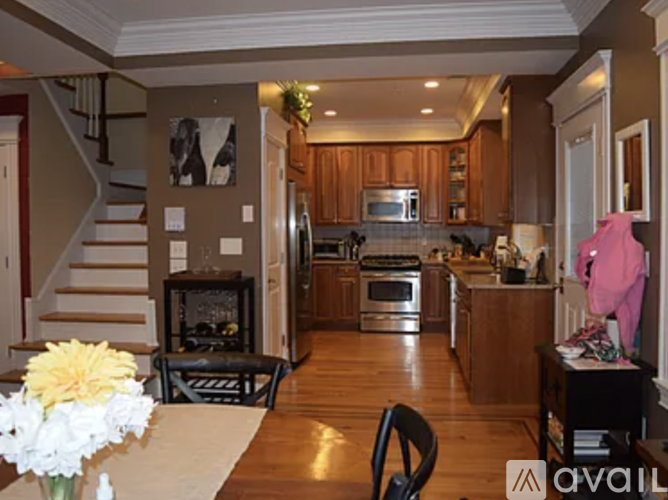 A kitchen with wooden cabinets and a staircase.