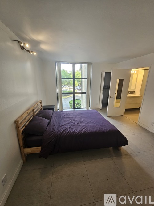 A bedroom with a bed and a window.
