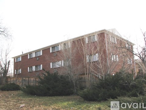 A red vehicle is parked in front of a brick building.