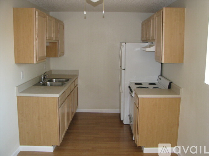 A kitchen with wooden cabinets and a white refrigerator.