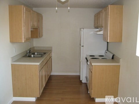 A kitchen with wooden cabinets and a white refrigerator.